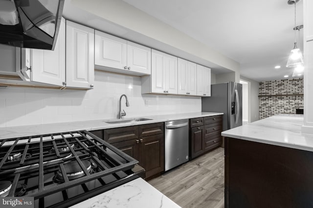 kitchen featuring appliances with stainless steel finishes, decorative backsplash, white cabinets, and sink