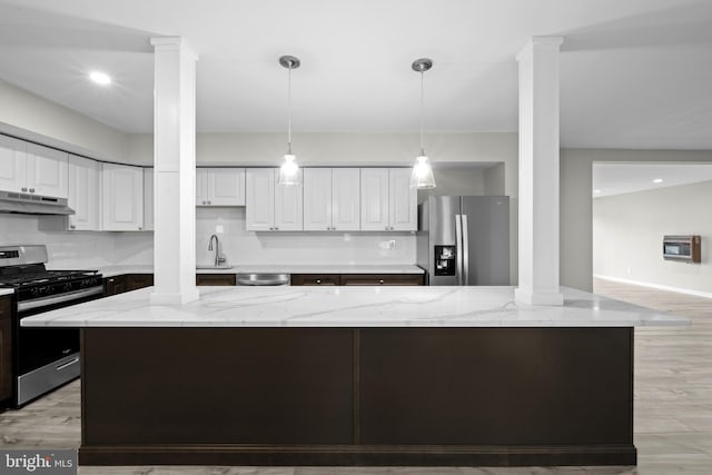 kitchen featuring white cabinets, light stone counters, stainless steel appliances, and a kitchen island