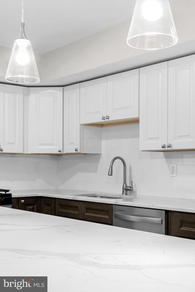 kitchen with stainless steel dishwasher, backsplash, sink, and white cabinetry