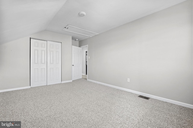 unfurnished bedroom with a closet, lofted ceiling, and carpet floors