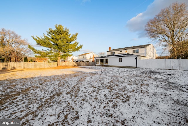 view of snow covered rear of property