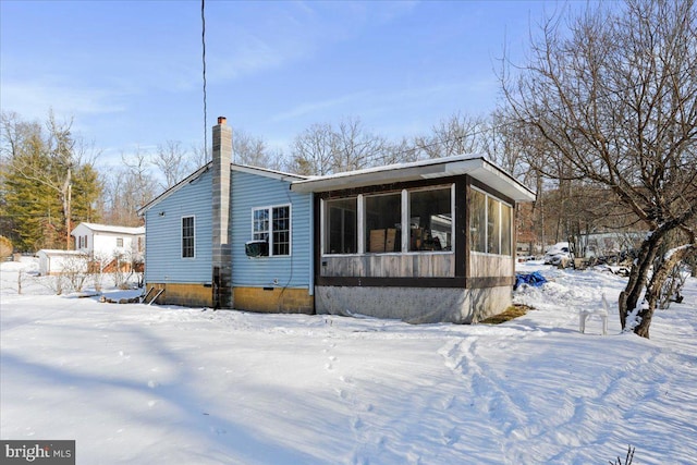 view of snow covered back of property