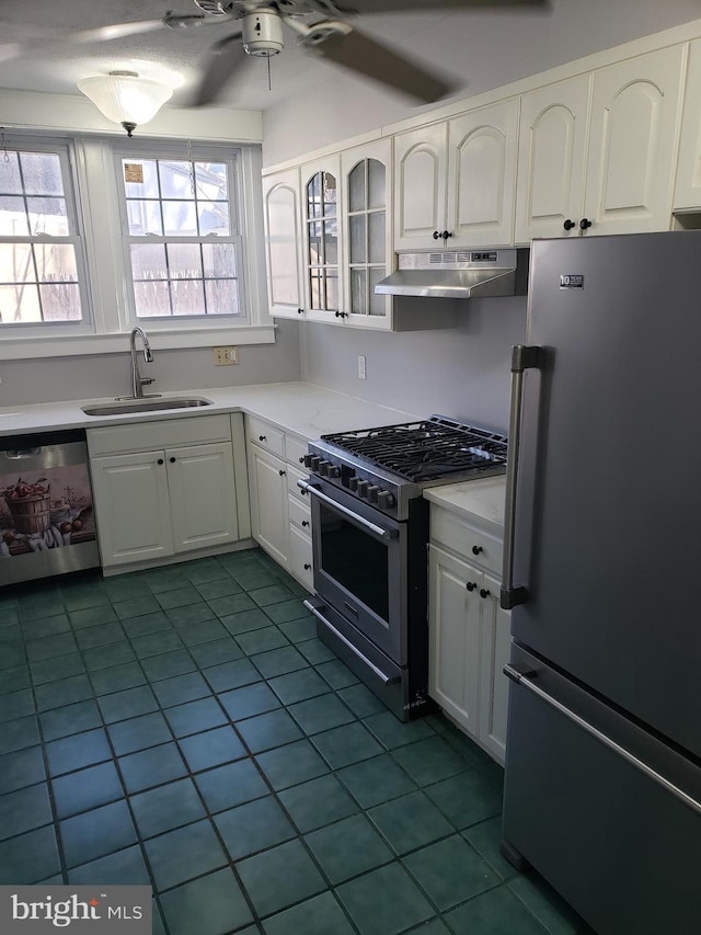 kitchen featuring tile patterned floors, white cabinetry, premium appliances, and sink