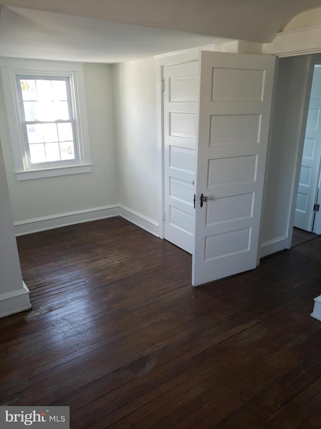 unfurnished bedroom with dark hardwood / wood-style floors