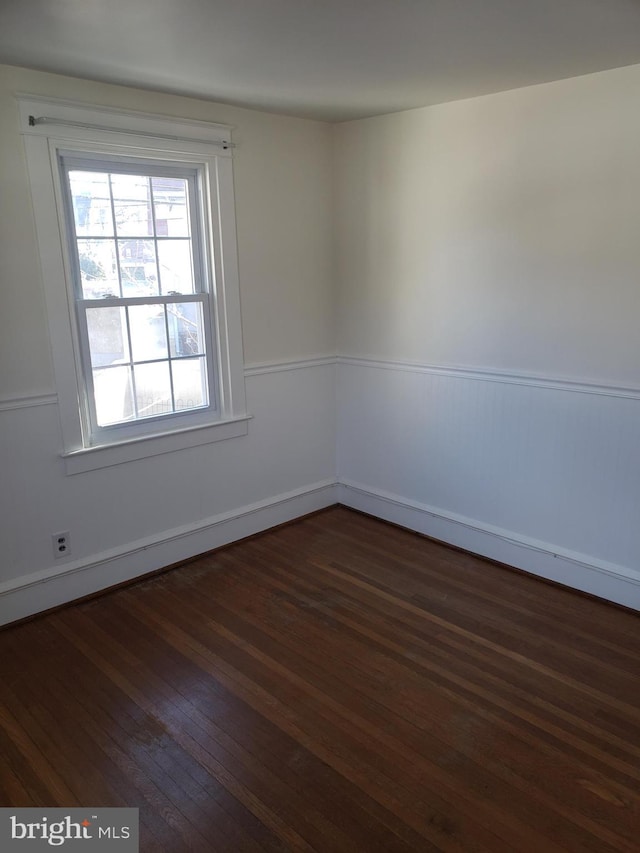 spare room with dark hardwood / wood-style floors