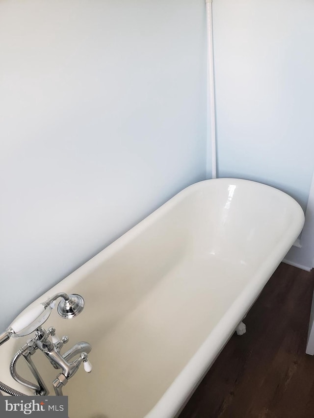 interior details featuring a bathing tub and hardwood / wood-style flooring