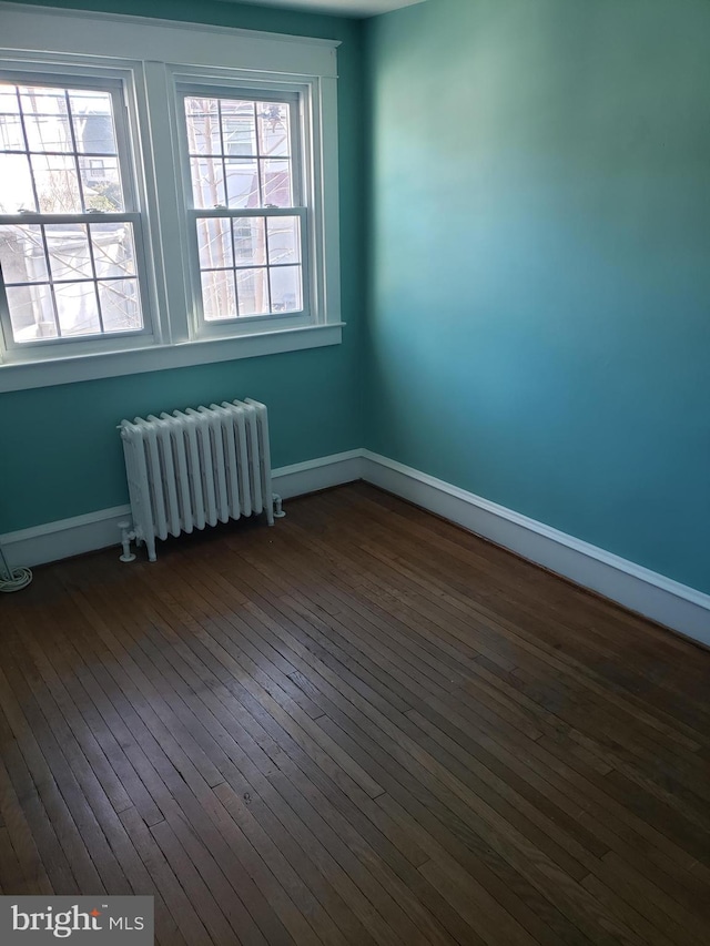 spare room with hardwood / wood-style flooring and radiator