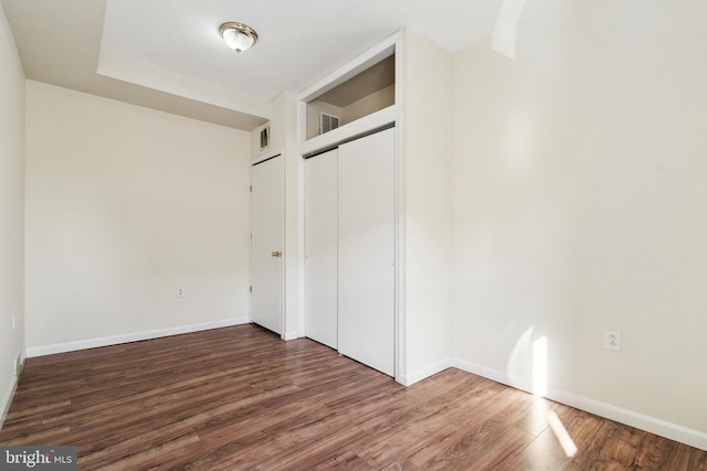 unfurnished bedroom featuring a closet and dark hardwood / wood-style floors