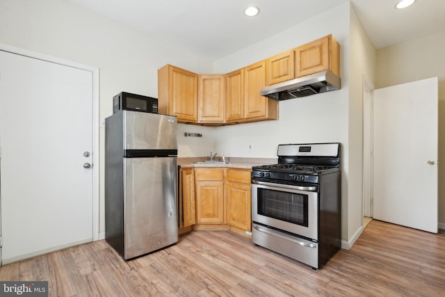 kitchen with light wood-type flooring, stainless steel appliances, light brown cabinets, and sink