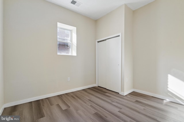 unfurnished bedroom with light wood-type flooring and a closet