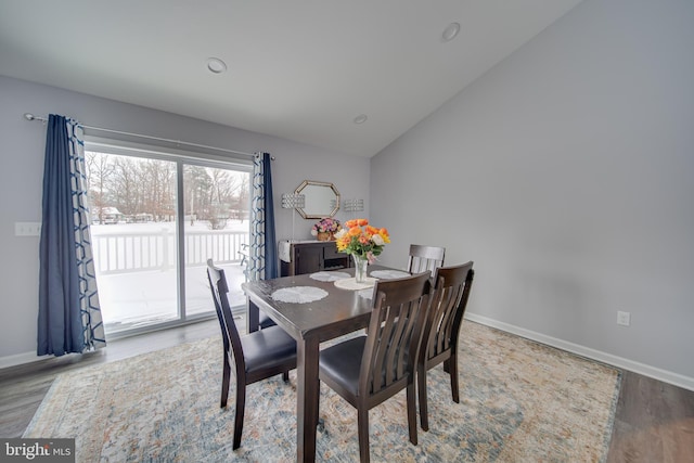 dining room with vaulted ceiling and light wood-type flooring