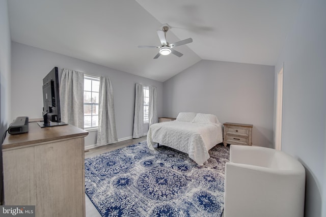 bedroom with ceiling fan, lofted ceiling, and wood-type flooring