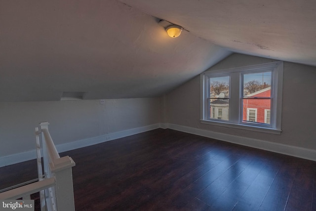 additional living space with vaulted ceiling and dark hardwood / wood-style flooring