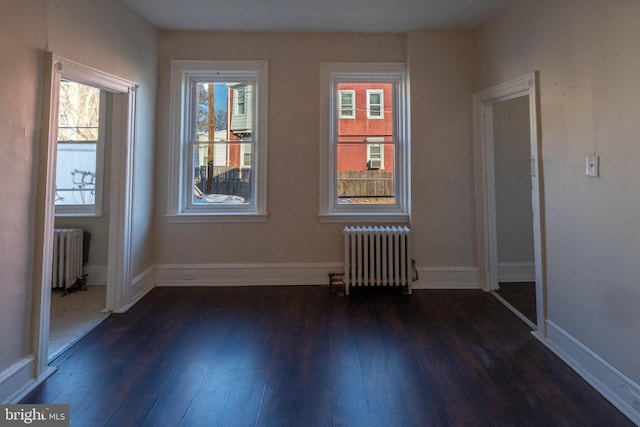 unfurnished room with radiator and dark hardwood / wood-style flooring