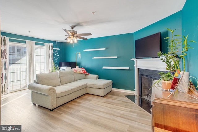 living room with ceiling fan and light wood-type flooring