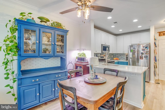 dining area with ornamental molding, sink, ceiling fan, and light hardwood / wood-style floors