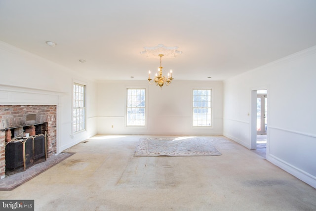 unfurnished living room featuring a brick fireplace, a chandelier, crown molding, and light colored carpet