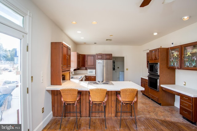 kitchen featuring sink, black appliances, kitchen peninsula, and a breakfast bar area