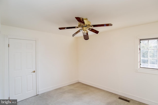 empty room featuring ceiling fan and light colored carpet