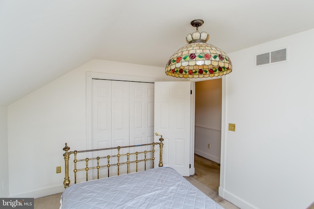 bedroom with vaulted ceiling, a closet, and carpet flooring