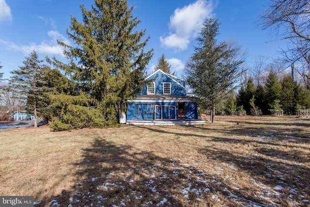 back of property with a lawn and a porch