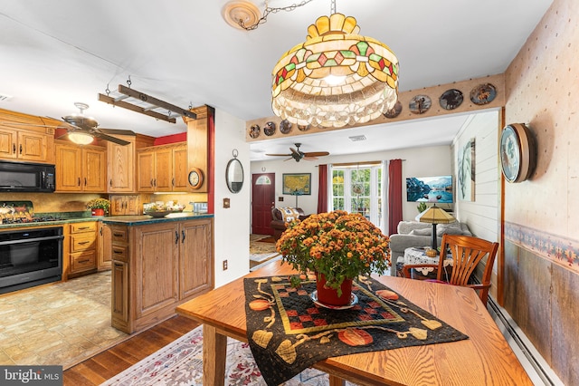 kitchen with ceiling fan, tasteful backsplash, a baseboard heating unit, light hardwood / wood-style floors, and wall oven