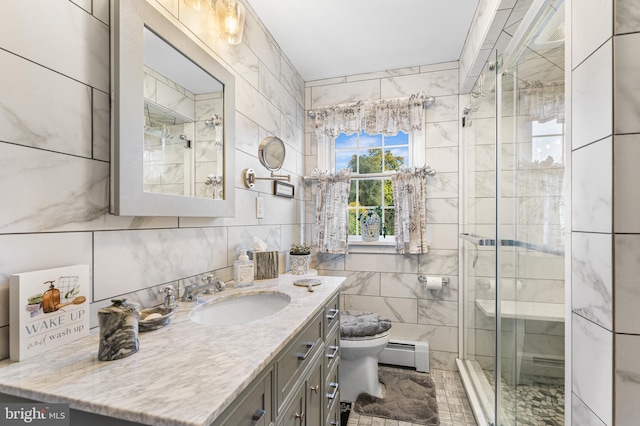 bathroom featuring a baseboard heating unit, vanity, tile walls, toilet, and a shower with shower door