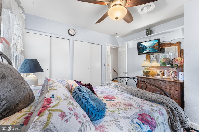 bedroom featuring ceiling fan and multiple closets