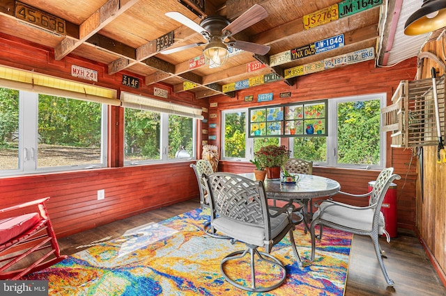 sunroom with ceiling fan and beamed ceiling