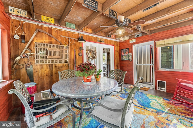 interior space featuring hardwood / wood-style floors, wooden walls, ceiling fan, wooden ceiling, and beam ceiling