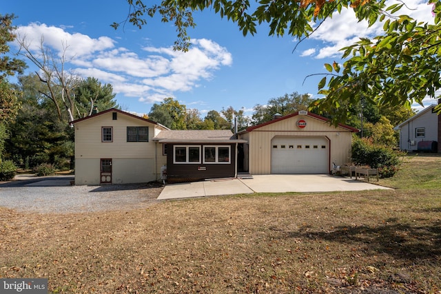 view of front of house with a garage, a patio area, a front lawn, and an outdoor structure