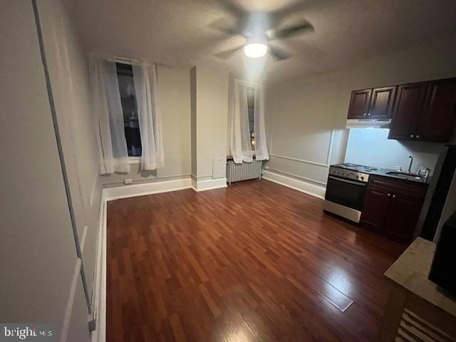 kitchen with radiator heating unit, sink, dark hardwood / wood-style floors, ceiling fan, and dark brown cabinets