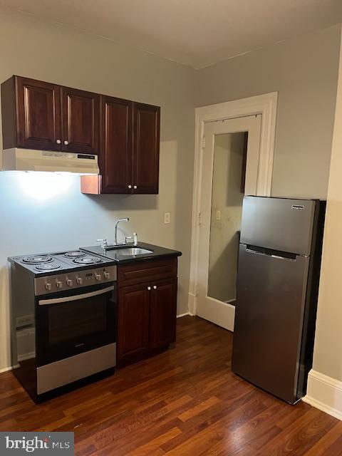 kitchen featuring dark brown cabinetry, appliances with stainless steel finishes, sink, and dark hardwood / wood-style floors