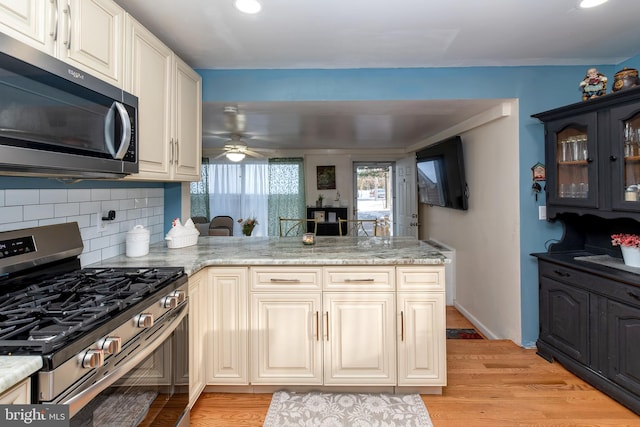 862 Bay Ave, Toms River, NJ 08753 - kitchen featuring stainless steel appliances, tasteful backsplash, light stone countertops, and kitchen peninsula