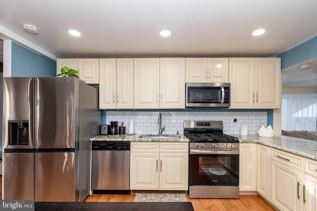862 Bay Ave, Toms River, NJ 08753 - kitchen with cream cabinets, sink, backsplash, stainless steel appliances, and light stone countertops