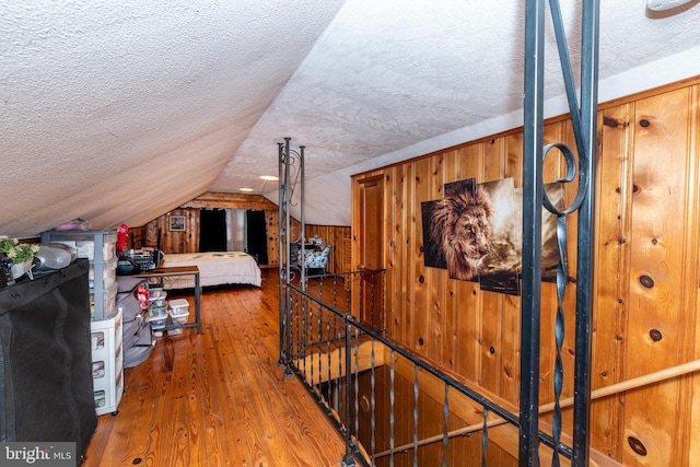 862 Bay Ave, Toms River, NJ 08753 - bedroom with hardwood / wood-style floors, vaulted ceiling, a textured ceiling, and wood walls