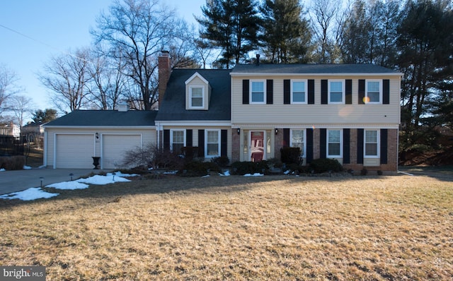 colonial house featuring brick siding, a front lawn, concrete driveway, a chimney, and a garage