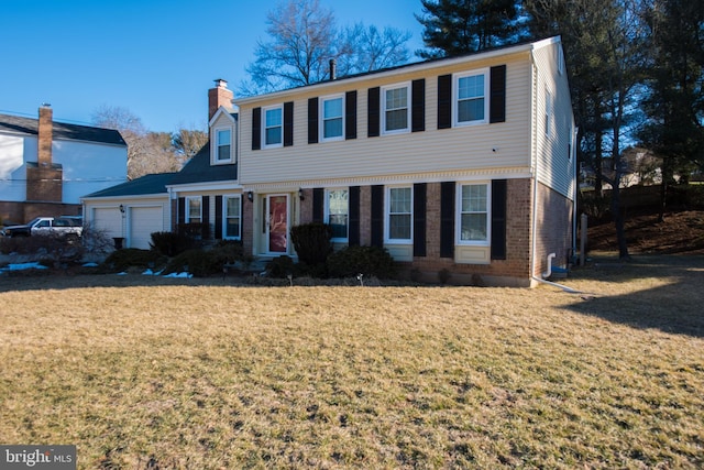 colonial home with brick siding, an attached garage, a chimney, and a front lawn