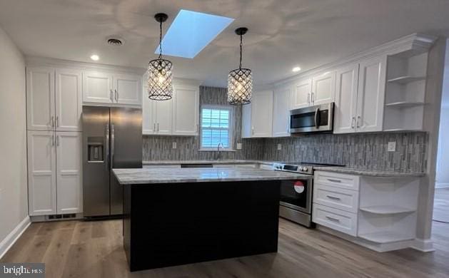 kitchen with white cabinetry, appliances with stainless steel finishes, and hanging light fixtures