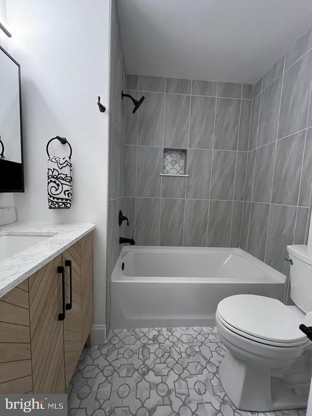 full bathroom with toilet, tiled shower / bath combo, tile patterned floors, and vanity