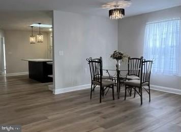 dining room with dark wood-type flooring and a notable chandelier