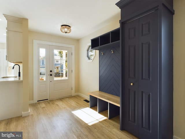 mudroom with light hardwood / wood-style floors and sink