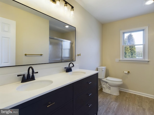 bathroom featuring a shower with shower door, wood-type flooring, toilet, and vanity