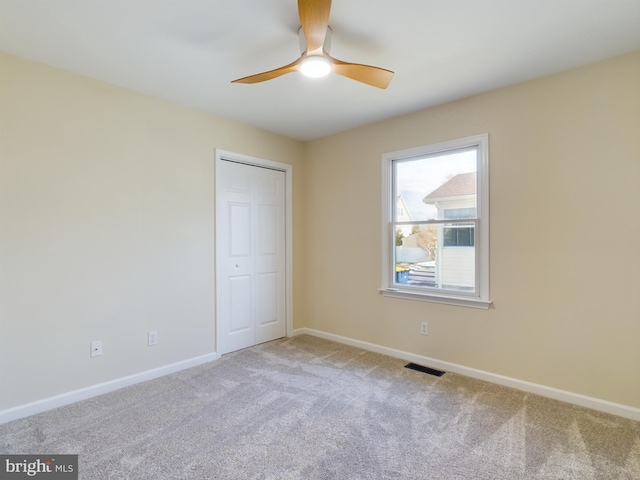 unfurnished bedroom with carpet floors, a closet, and ceiling fan