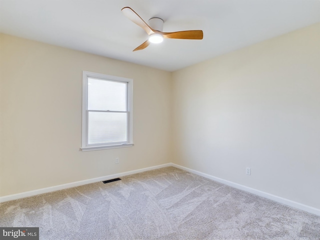 carpeted spare room featuring ceiling fan