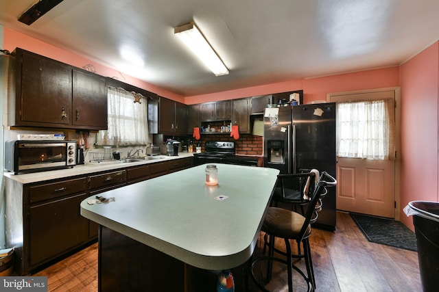 kitchen with plenty of natural light, sink, black appliances, and dark brown cabinets