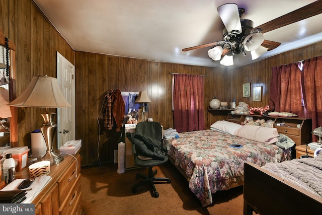 carpeted bedroom with ceiling fan and wood walls