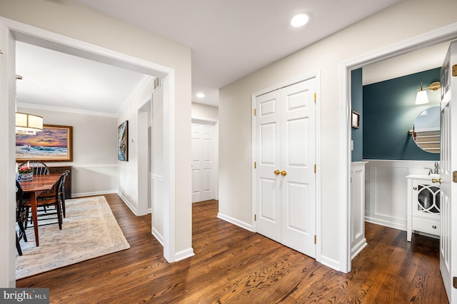 hallway with crown molding and dark hardwood / wood-style flooring