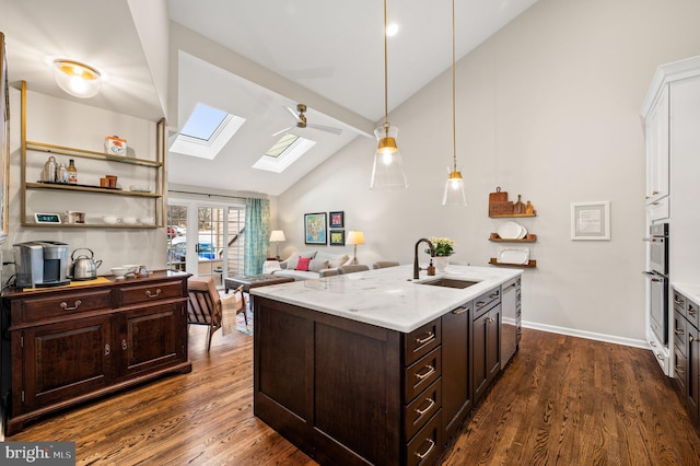 kitchen with a skylight, sink, hanging light fixtures, dark wood-type flooring, and dark brown cabinets