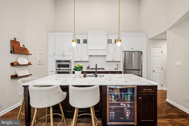 kitchen featuring white cabinetry, appliances with stainless steel finishes, wine cooler, and light stone counters